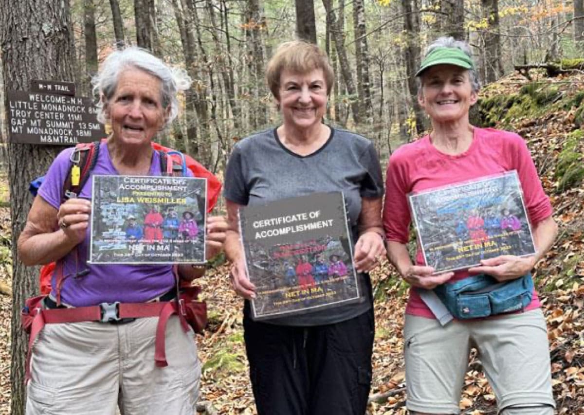 Four hikers holding certificates of completion